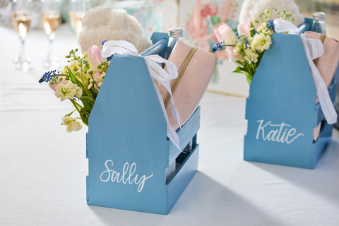 thumbnail Give bridesmaid gifts a personal touch without overspending. 2X Ultra Cover Satin Spray in Satin French Blue transforms basic champagne caddies into cherished keepsakes. (Photo: Business Wire)
